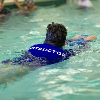a man swimming in a pool instructing swim school