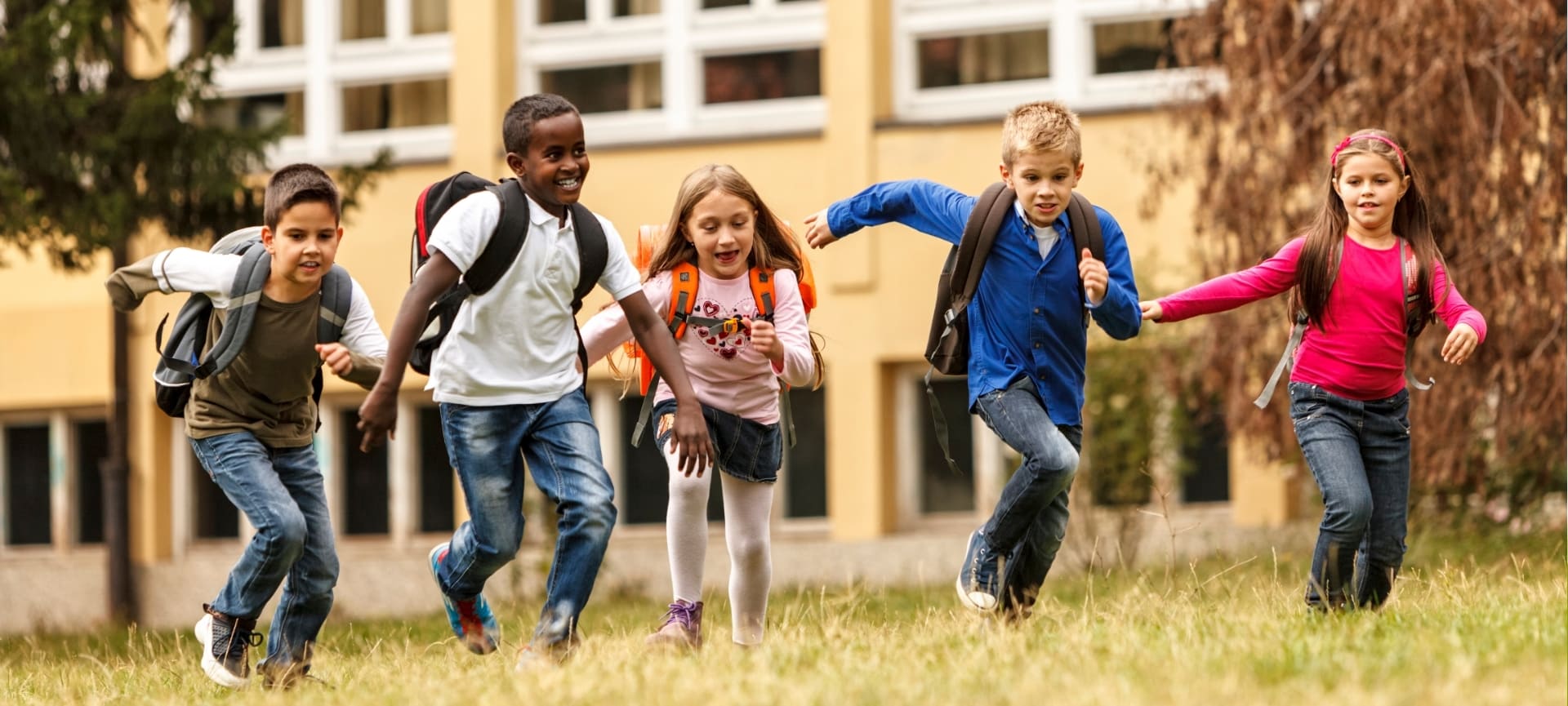 a group of kids running in a grassy area | before and after school care
