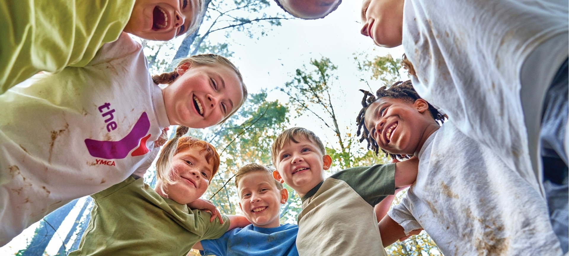 Children playing and laughing with each other in a circle outdoors. | Youth Development