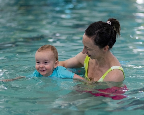 a woman and baby swimming in a pool