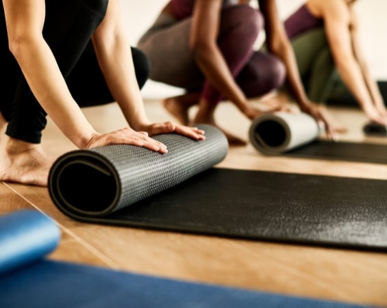 a group of people rolling yoga mats | functional fitness