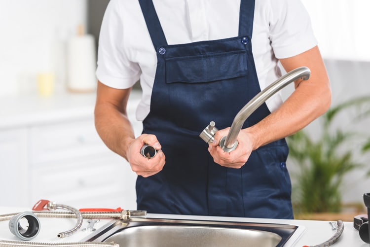 Repairman removing a kitchen faucet