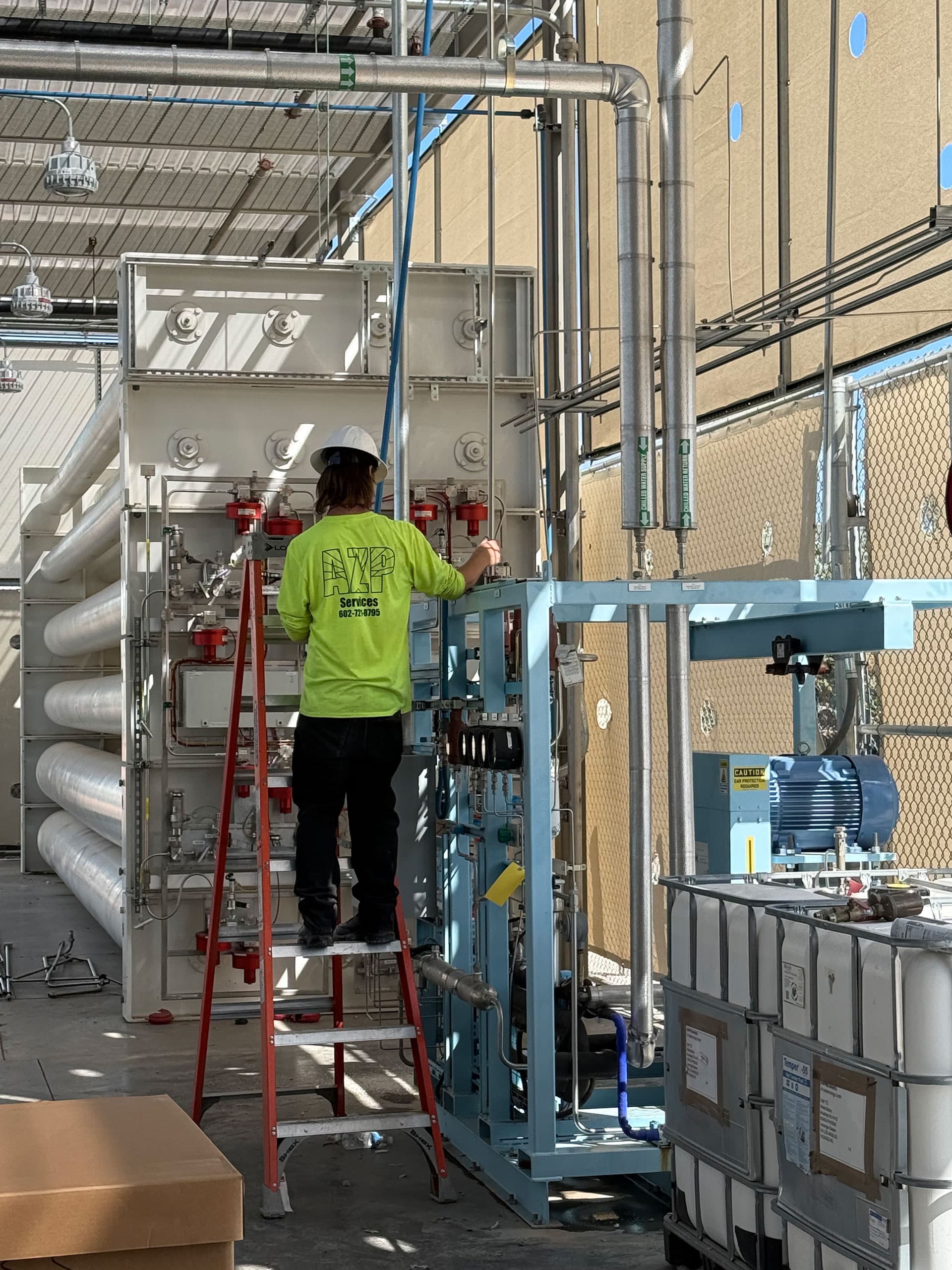 Technician on a ladder at a commercial system